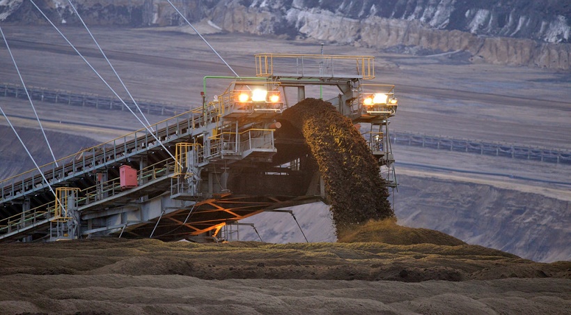 guindaste com uma correia despejando material de mineração