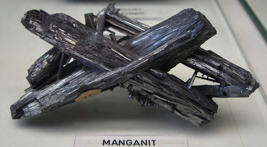 Prismas de coloração cinza escuro e brilho metálico do mineral manganita
