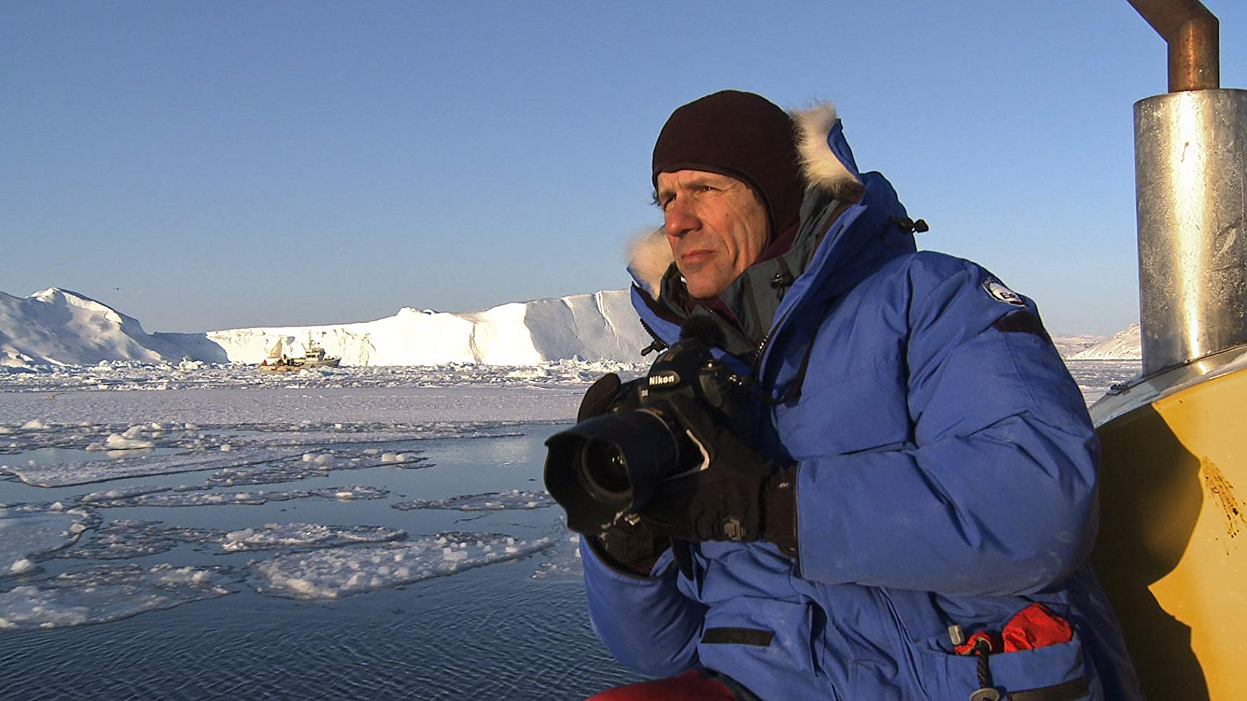 Homem com uma câmera fotográfica entre geleiras