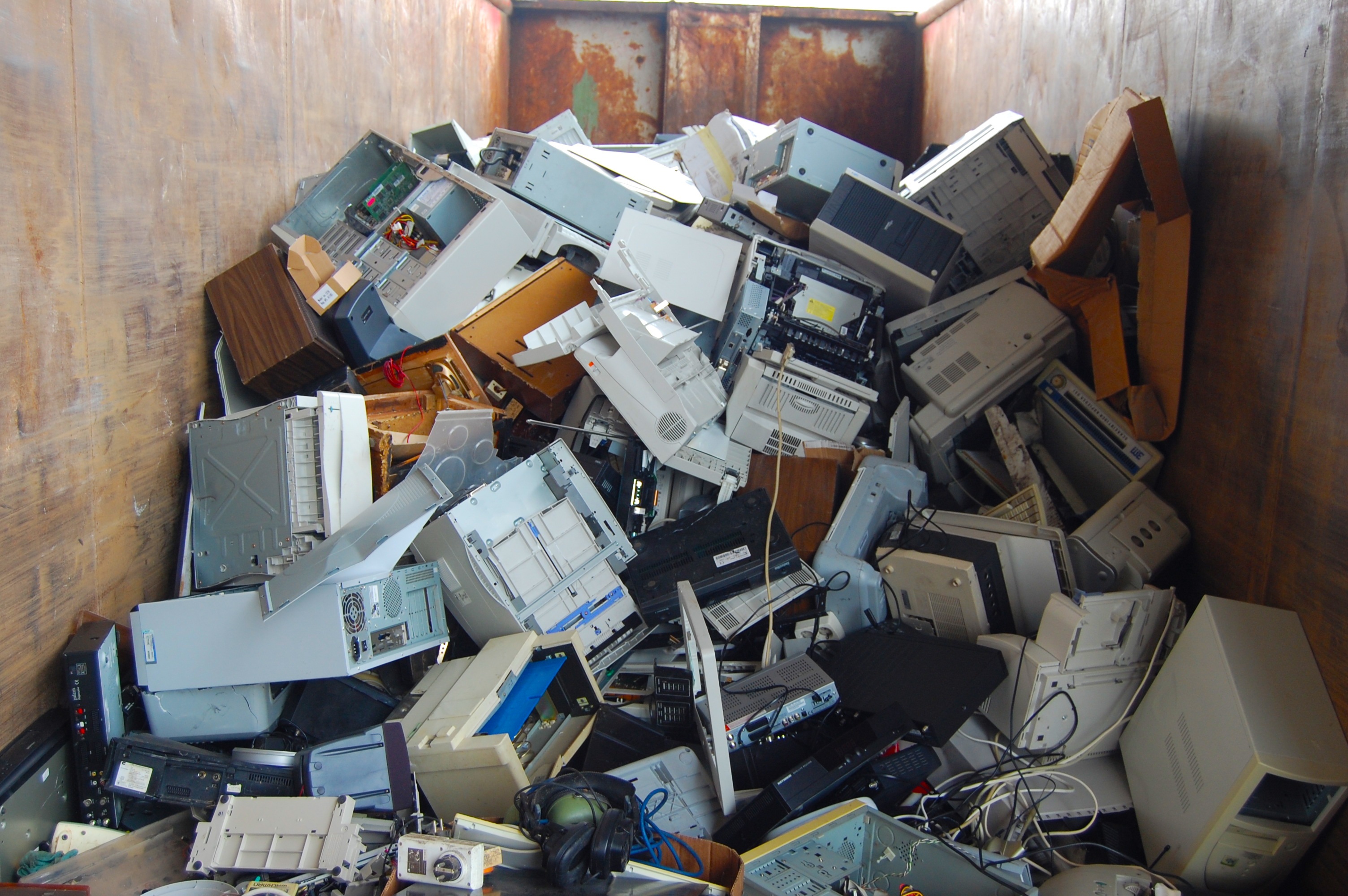 Compartimento contendo muitos computadores e outros lixos eletrônicos.