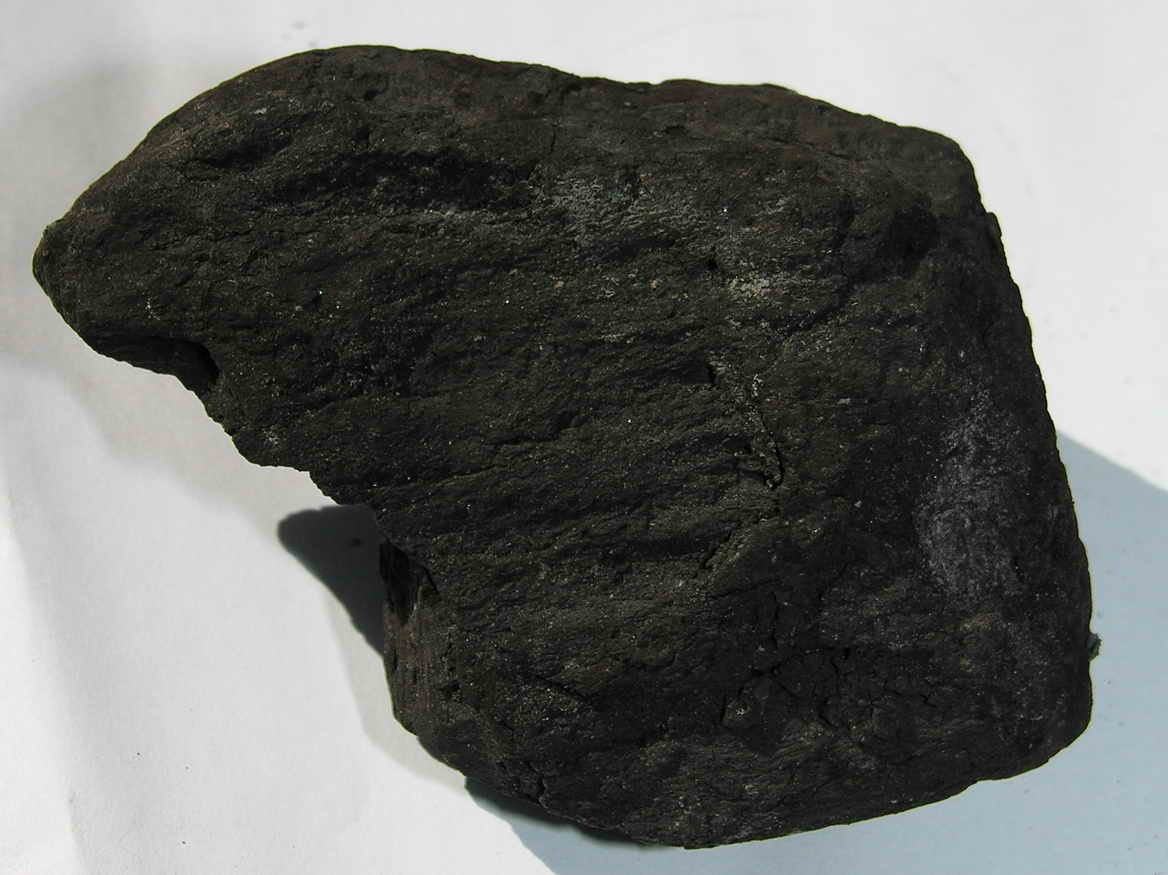 Imagem mostrando uma pedra preta de carvão mineral, bem escura.