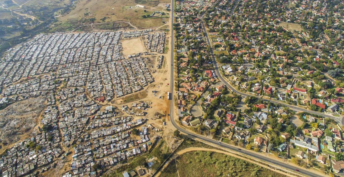 Foto aérea da divisa dos bairro Bloubosrand e do assentamento irregular de Kya Sands. Imagem que exemplifica a desigualdade sul-africana. (Foto: Johnny Miller)