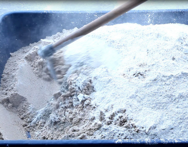 Cal hidratada sendo misturada à areia. Aditivo usado em argamassa e concreto. Uma das formas de aproveitamento do caulim